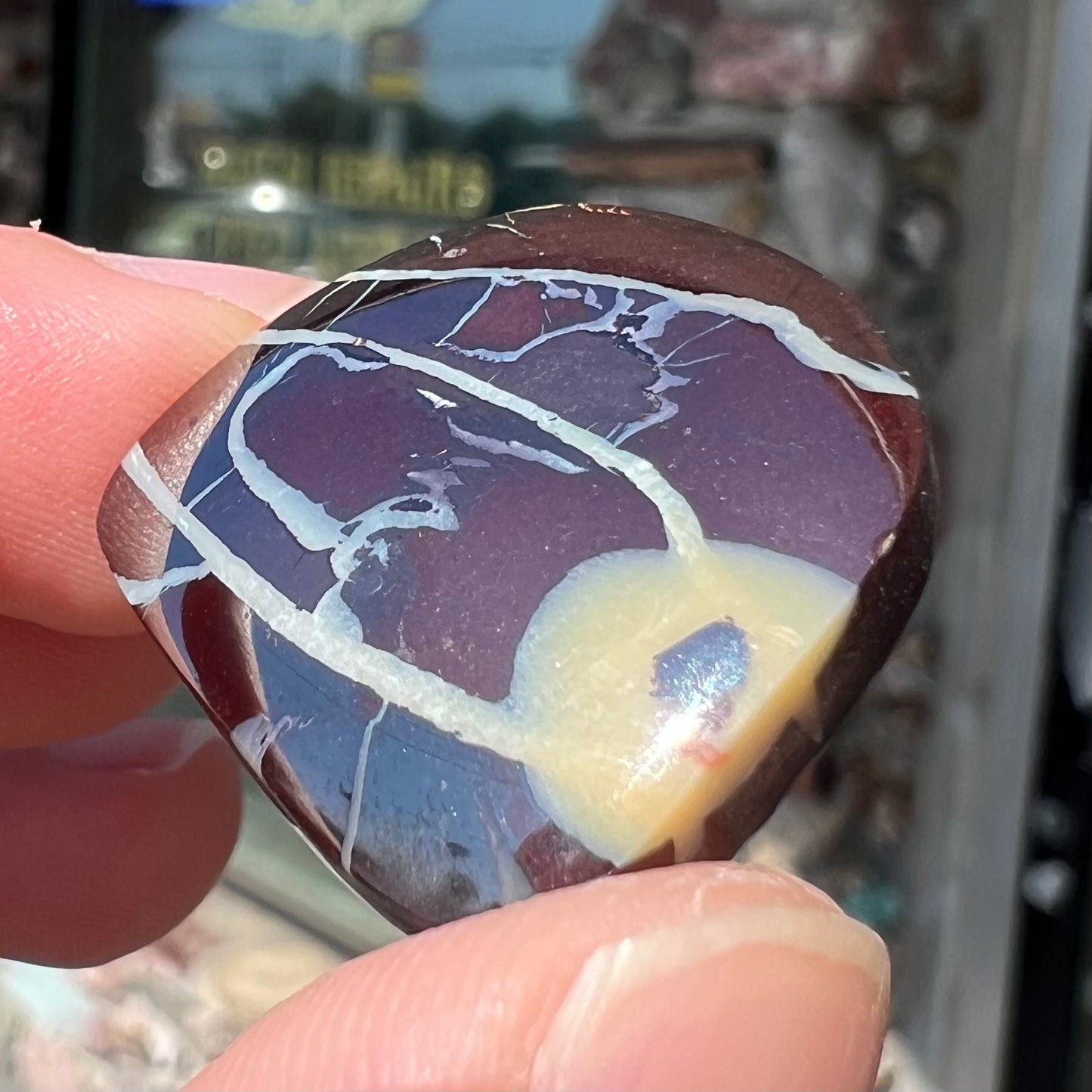 A polsihed, freeform Yowah nut opal specimen.  The stone is ironstone with common opal potch inclusions.