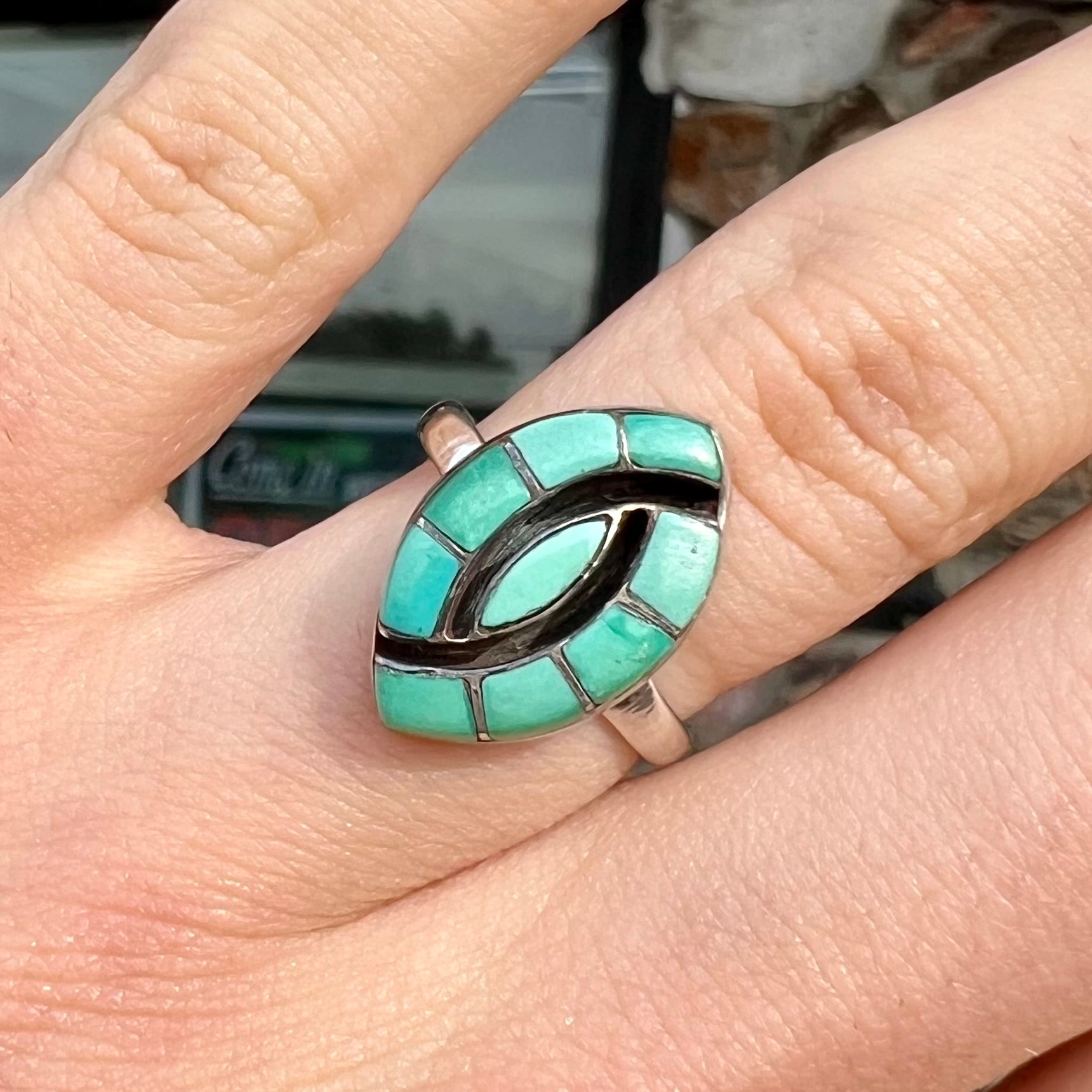 Vintage sterling silver Zuni Indian ring inlay set with green turquoise stones in the motif of a hummingbird.