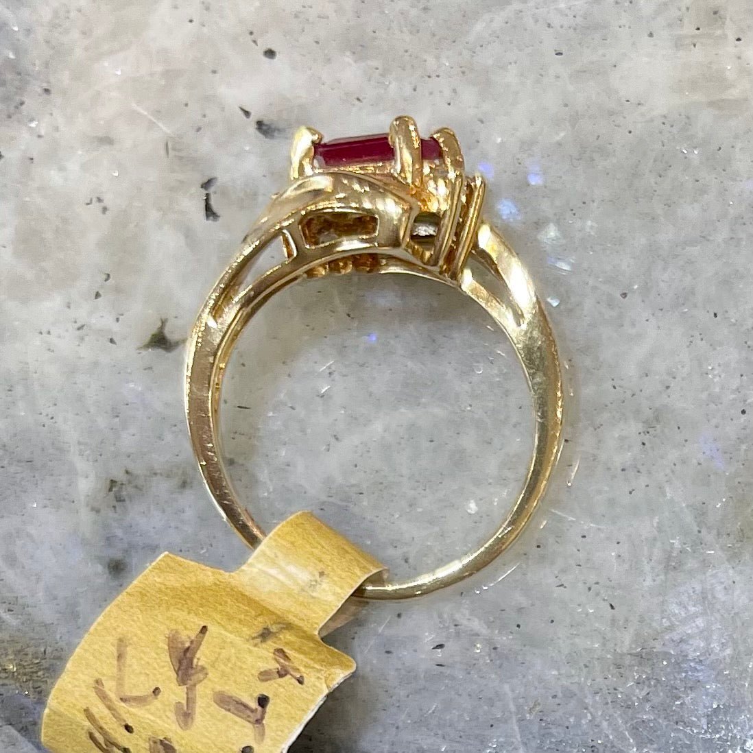 Emerald cut Burma ruby and diamond ring set in 14 karat yellow gold.