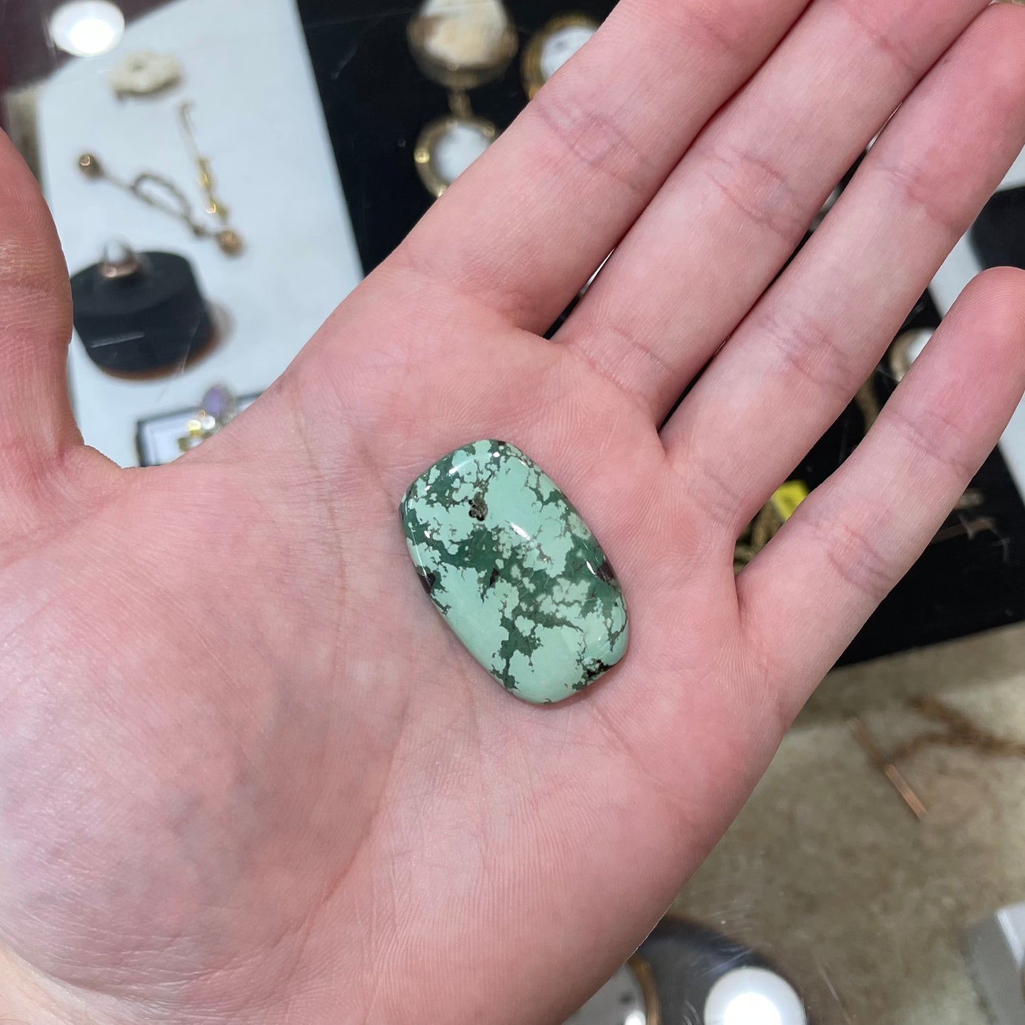 A loose, barrel cabochon cut variscite stone from Utah, USA.