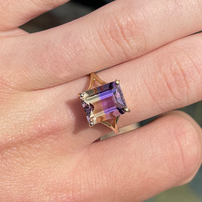 A split shank solitaire ametrine ring made with 14kt yellow gold.