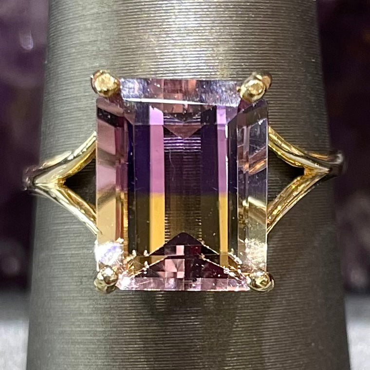 A split shank solitaire ametrine ring made with 14kt yellow gold.