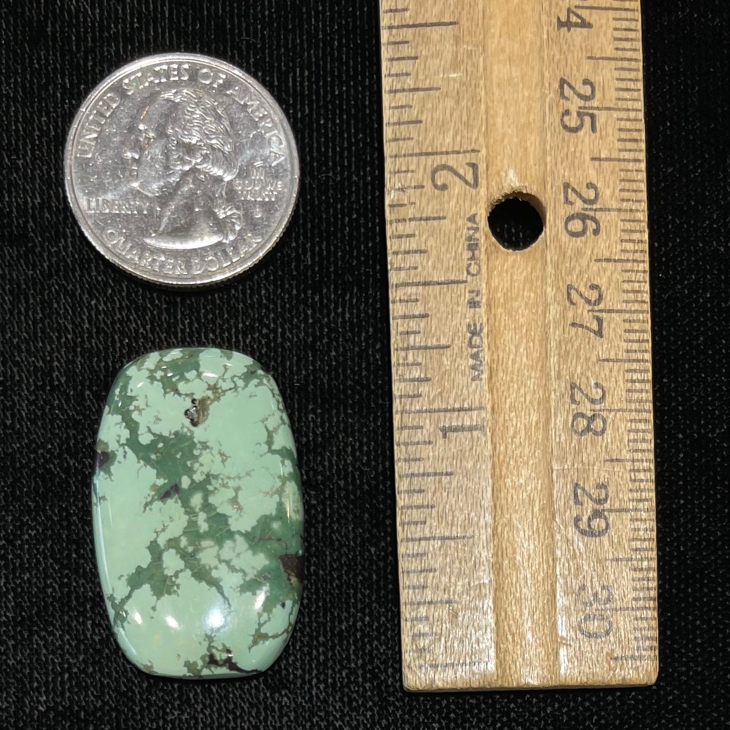 A loose, barrel cabochon cut variscite stone from Utah, USA.