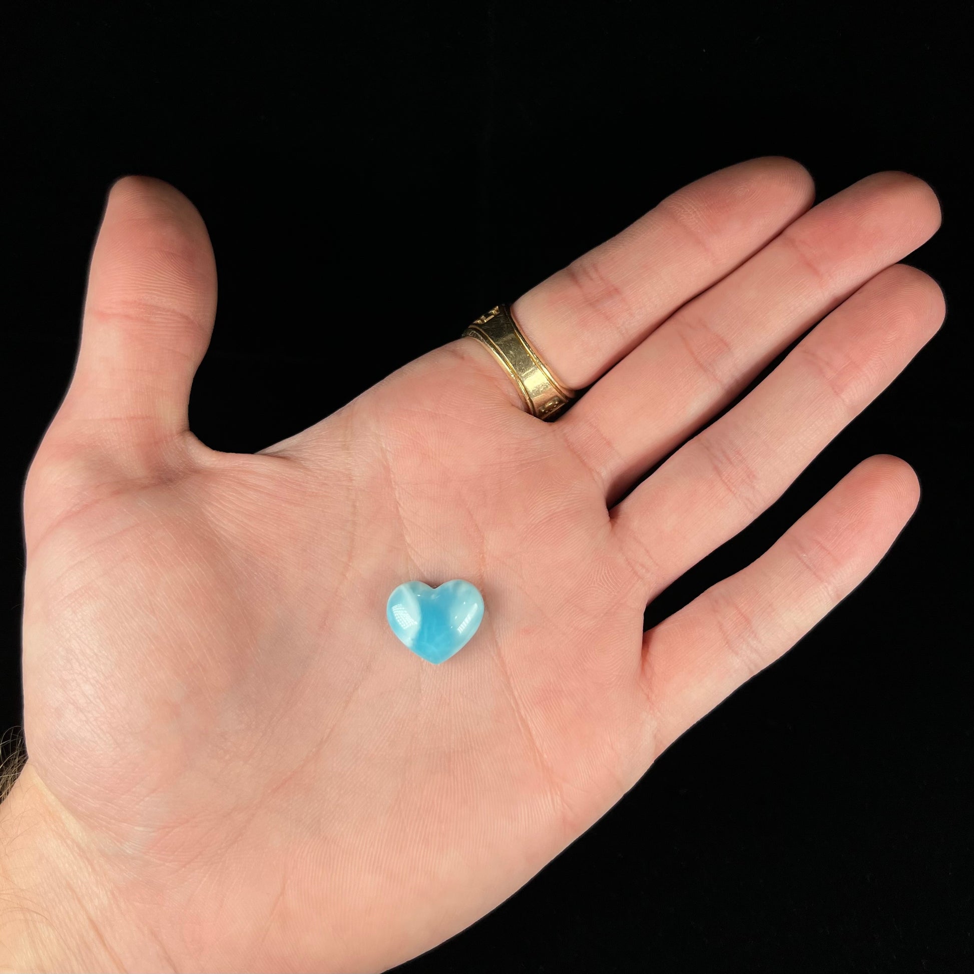 A loose, heart shaped cabochon cut larimar stone.