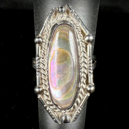 A Southwest style sterling silver ring set with a pink, oval cabochon cut mother of pearl shell.