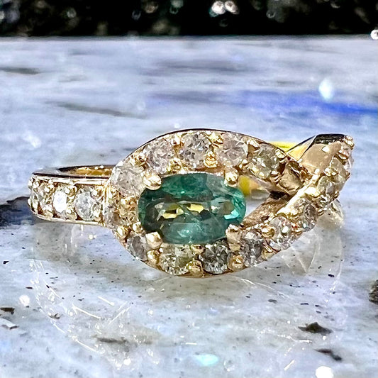 Yellow gold alexandrite and pave set diamond ring resting on labradorite tile.