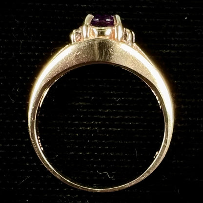 A ladies split shank gold ring set with an oval cut amethyst and round brilliant diamond accents.