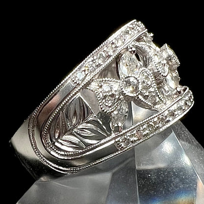 An art nouveau style 18k white gold ring set with round and marquise cut diamonds.