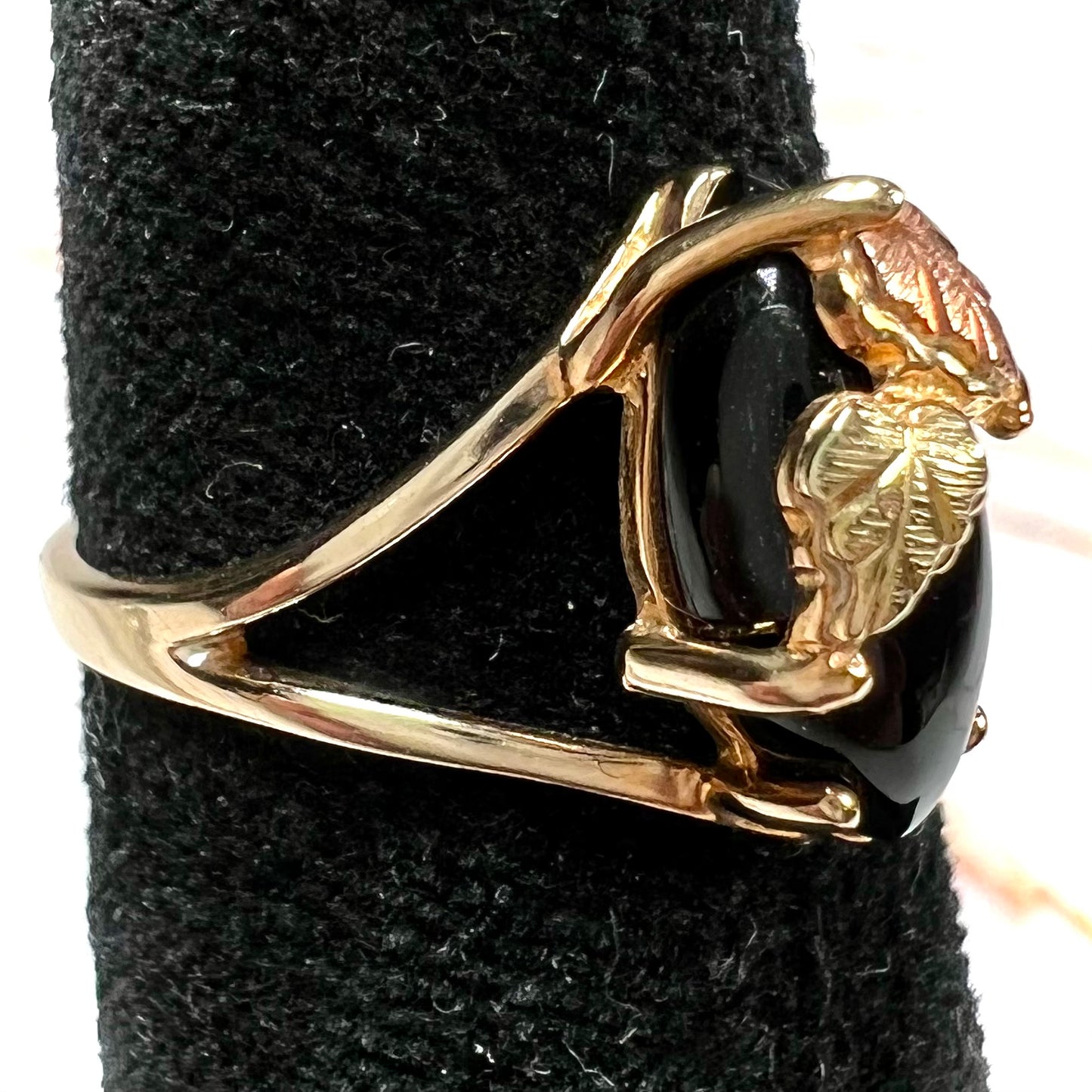 A split shank Black Hills gold ring set with a cabochon marquise cut black onyx.