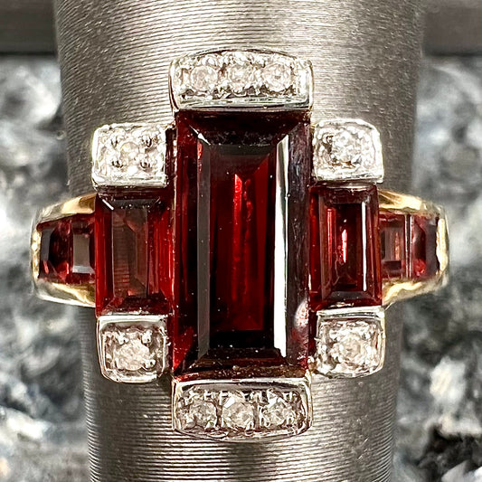 An Art Deco style emerald cut garnet and diamond ring cast in yellow gold.