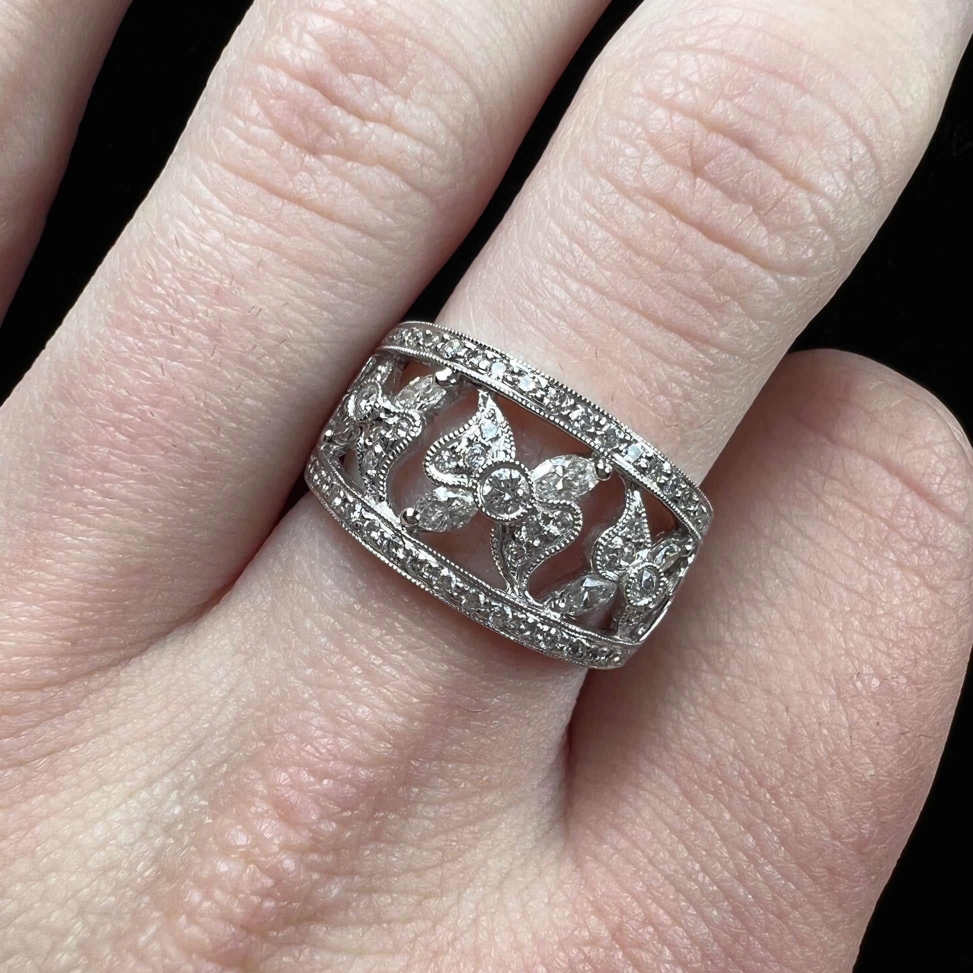 An art nouveau style 18k white gold ring set with round and marquise cut diamonds.