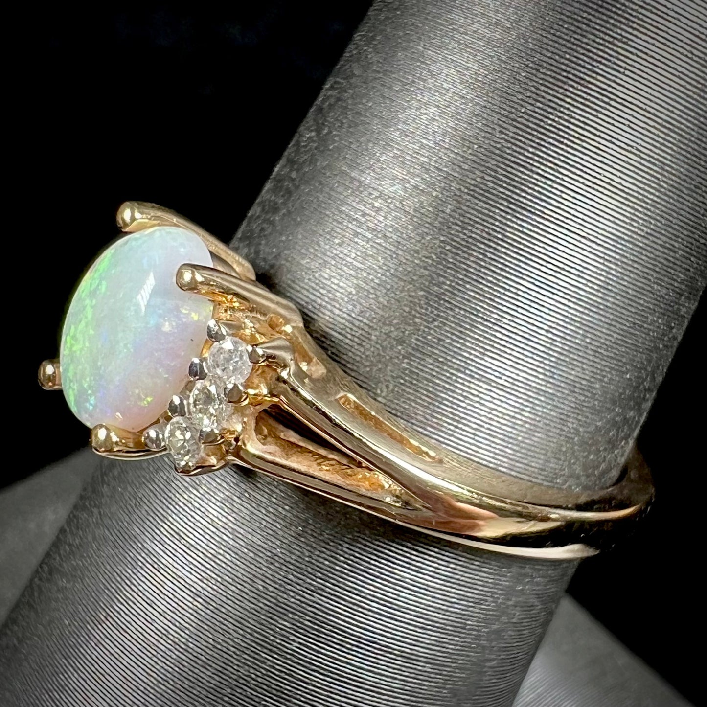 A ladies' yellow gold Coober Pedy, Australian opal ring set with three round cut diamonds.