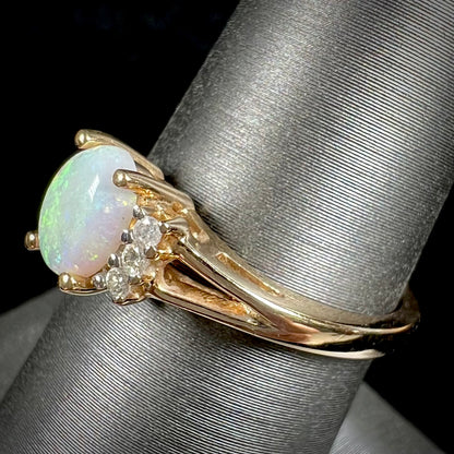 A ladies' yellow gold Coober Pedy, Australian opal ring set with three round cut diamonds.