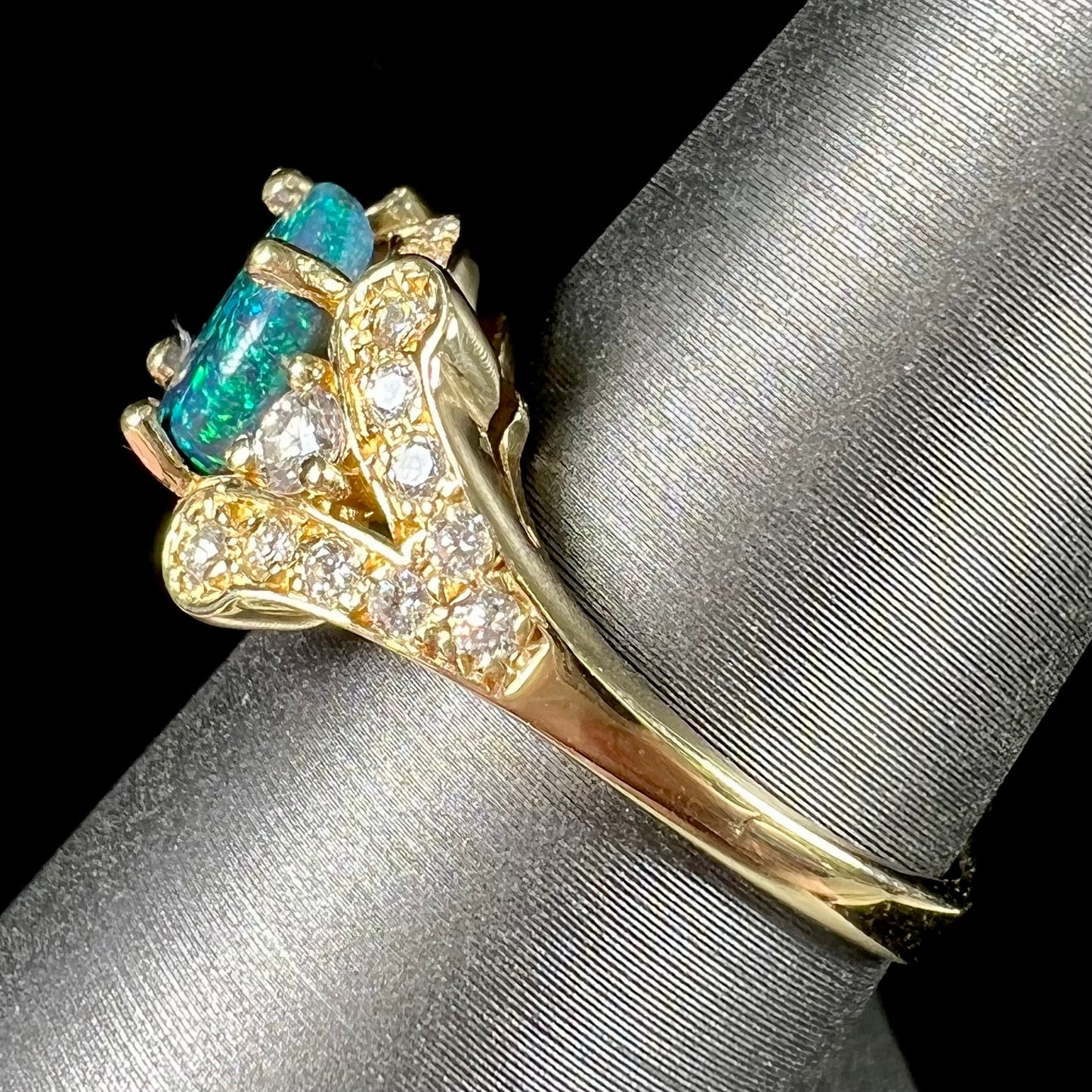 A ladies' 18kt yellow gold Lightning Ridge black opal and pave set diamond ring.