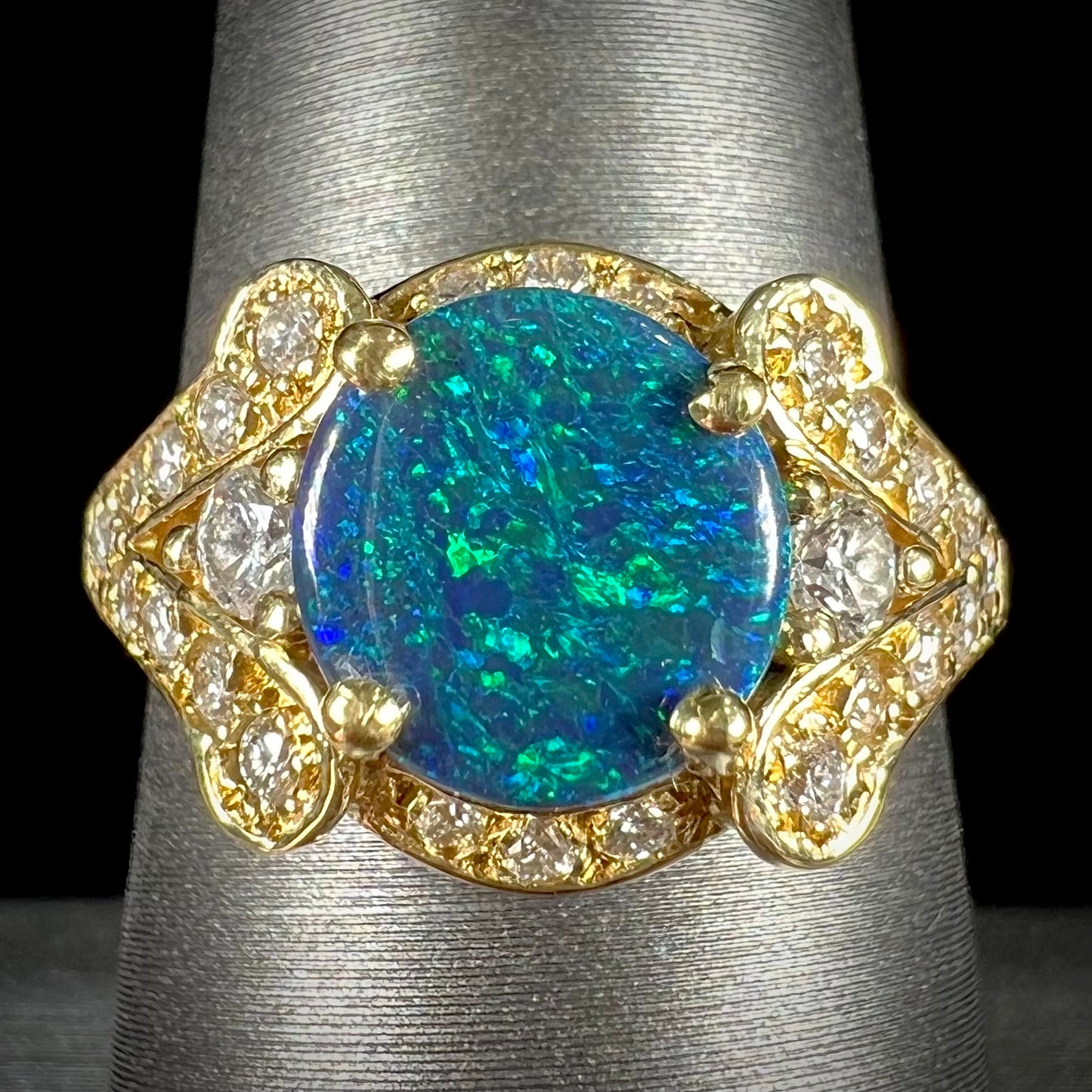 A ladies' 18kt yellow gold Lightning Ridge black opal and pave set diamond ring.