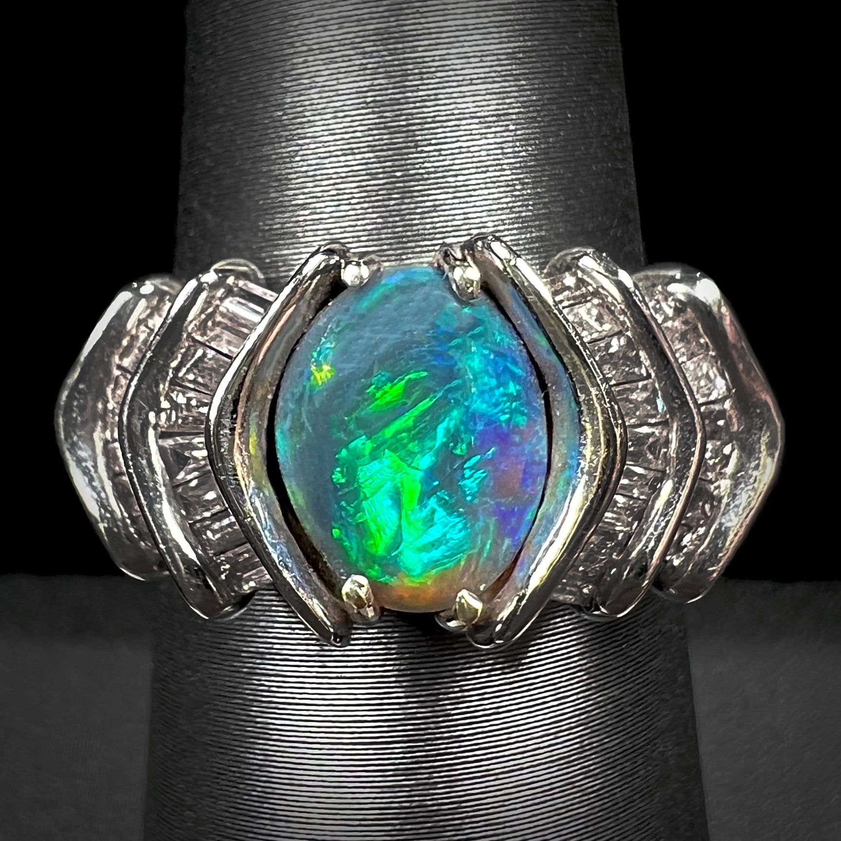 A white gold ring set with a Lightning Ridge natural black opal and baguette cut diamonds.