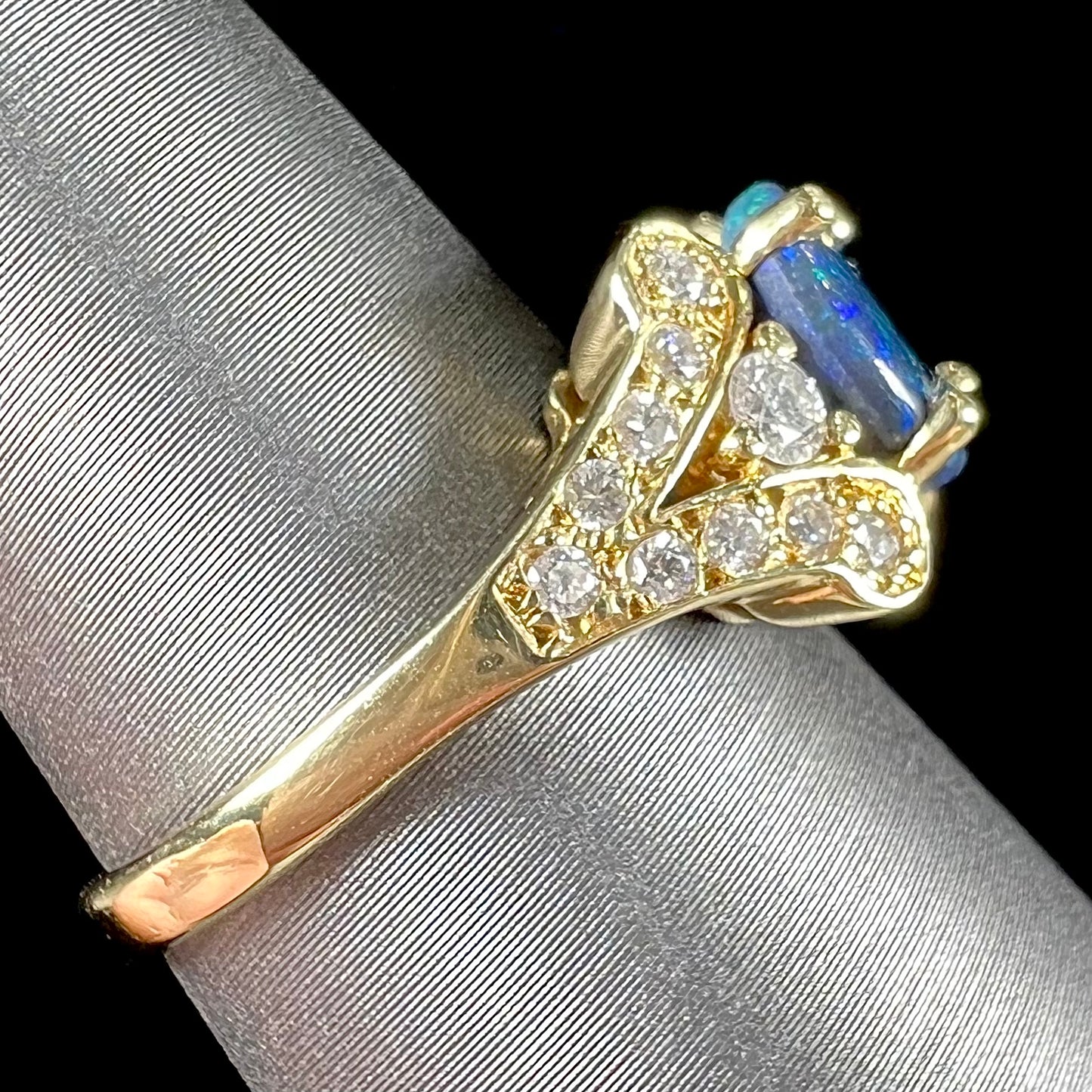 A ladies' 18kt yellow gold Lightning Ridge black opal and pave set diamond ring.