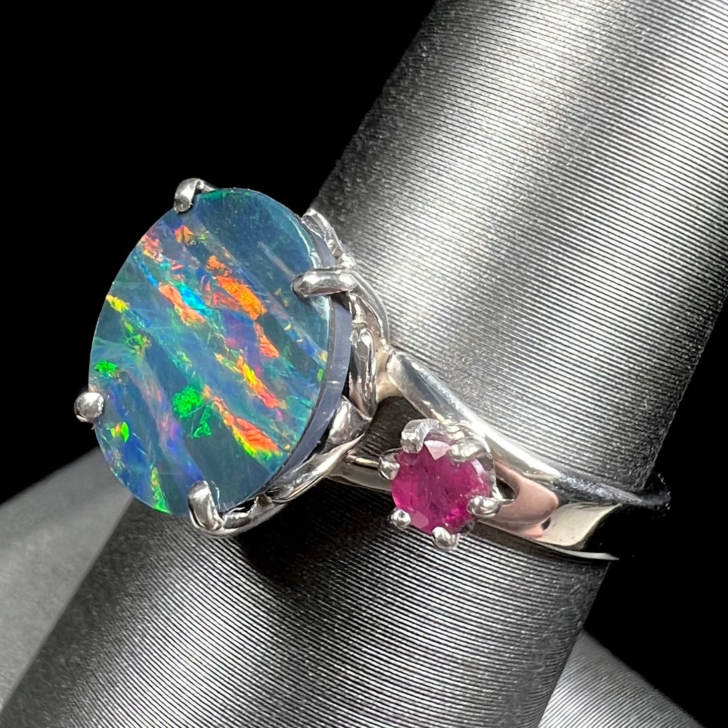 A ladies' 14kt white gold Australian black boulder opal doublet ring set with two round cut rubies.