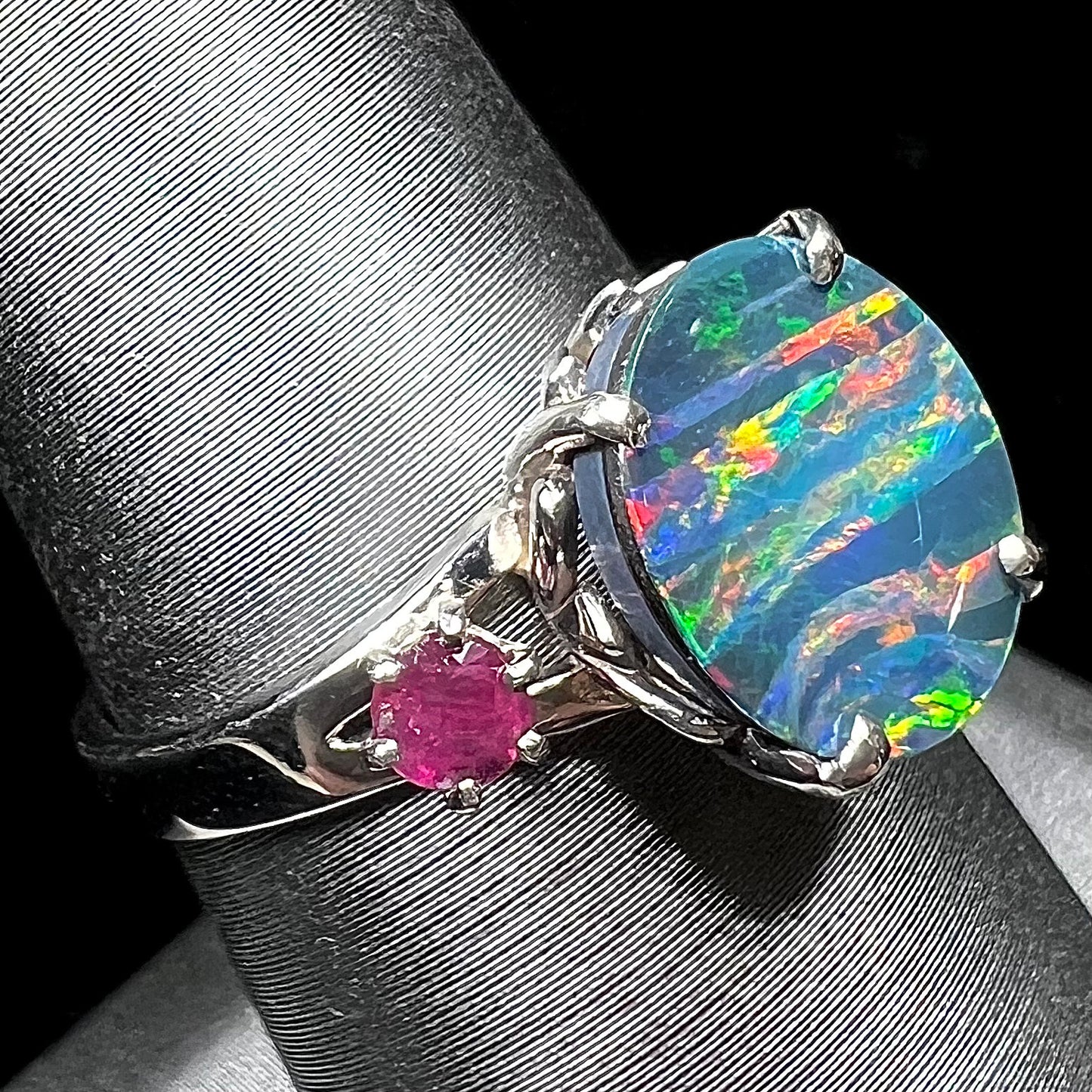 A ladies' 14kt white gold Australian black boulder opal doublet ring set with two round cut rubies.