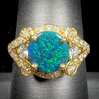 A ladies' 18kt yellow gold Lightning Ridge black opal and pave set diamond ring.