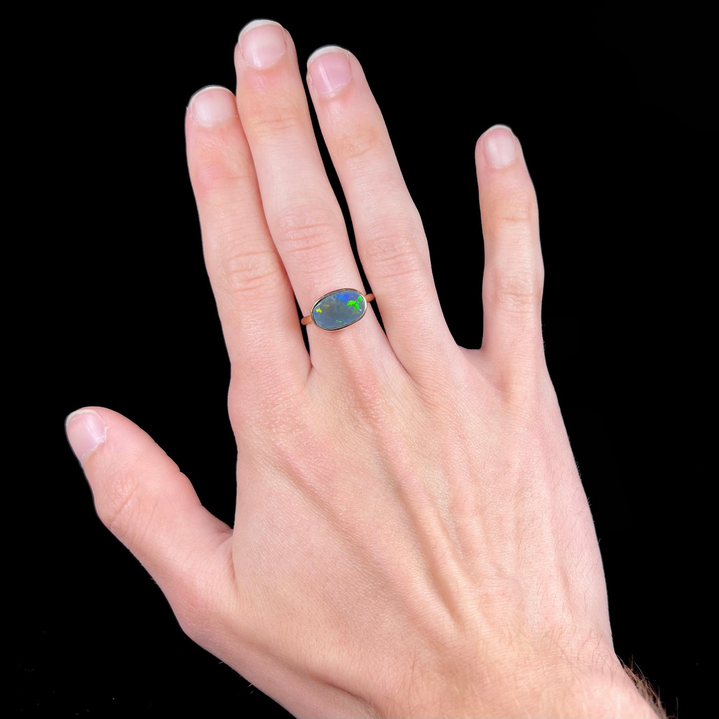 A ladies' yellow gold black opal solitaire ring from Lightning Ridge, Australia.