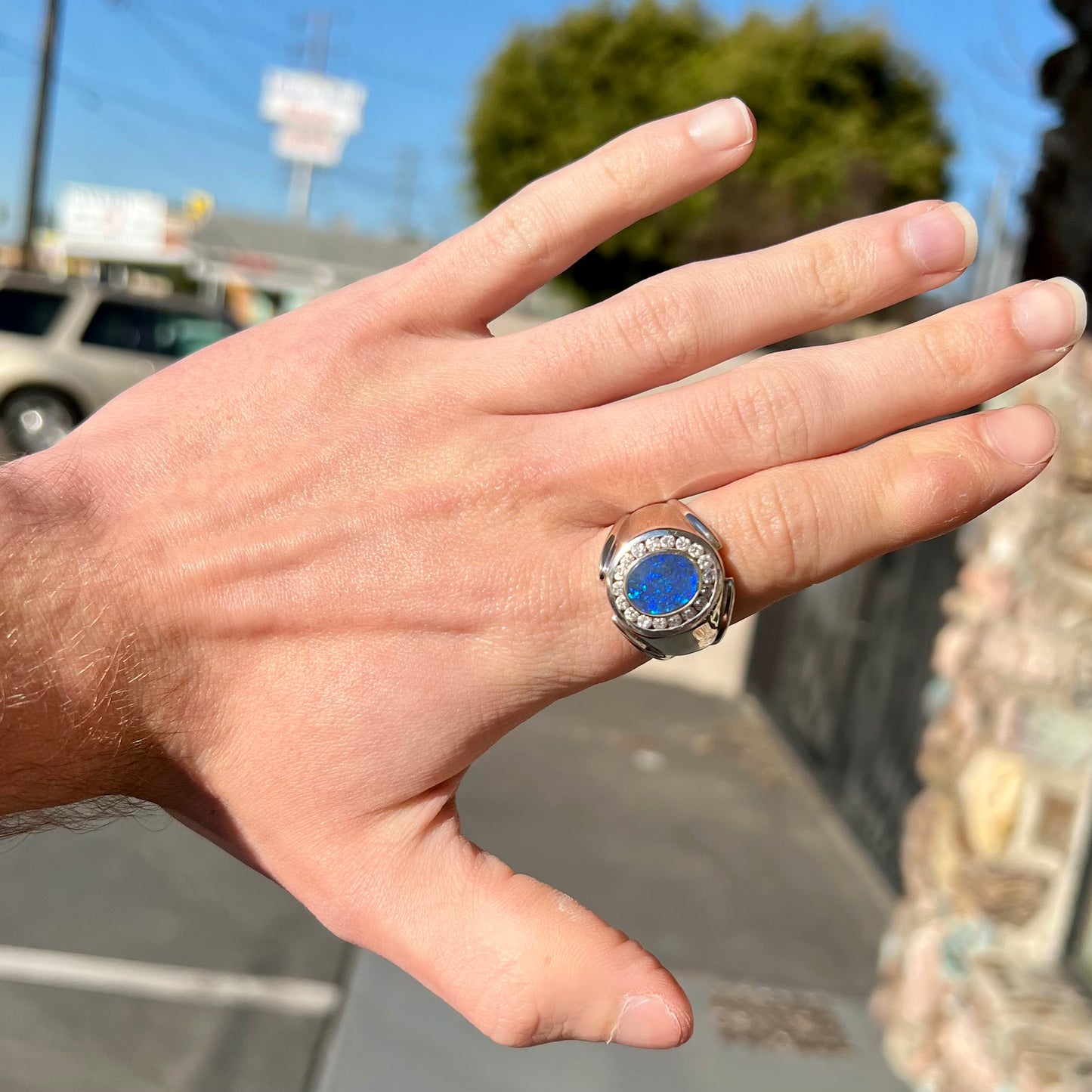 A men's black crystal opal and diamond halo ring in white gold.