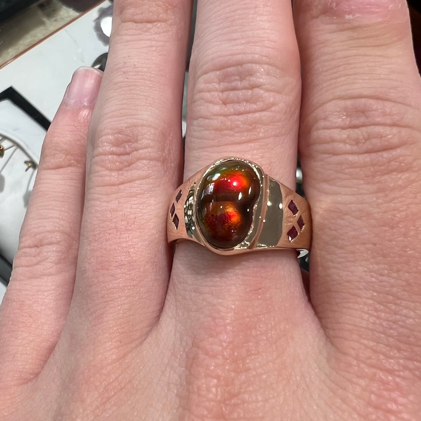 A yellow gold men's ring set with princess cut Burma rubies and a freeform cabochon cut red fire agate from Slaughter Mountain, Arizona.