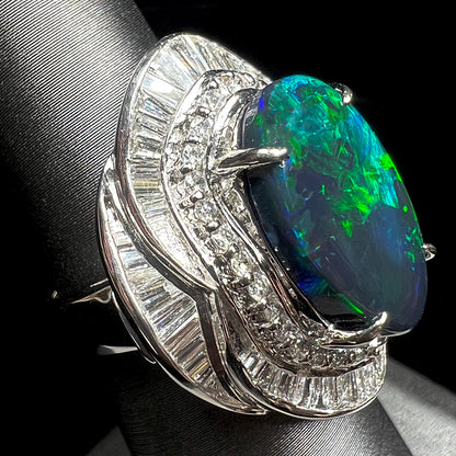 A ladies' platinum diamond halo ring set with a natural black opal stone from Lightning Ridge, Australia.