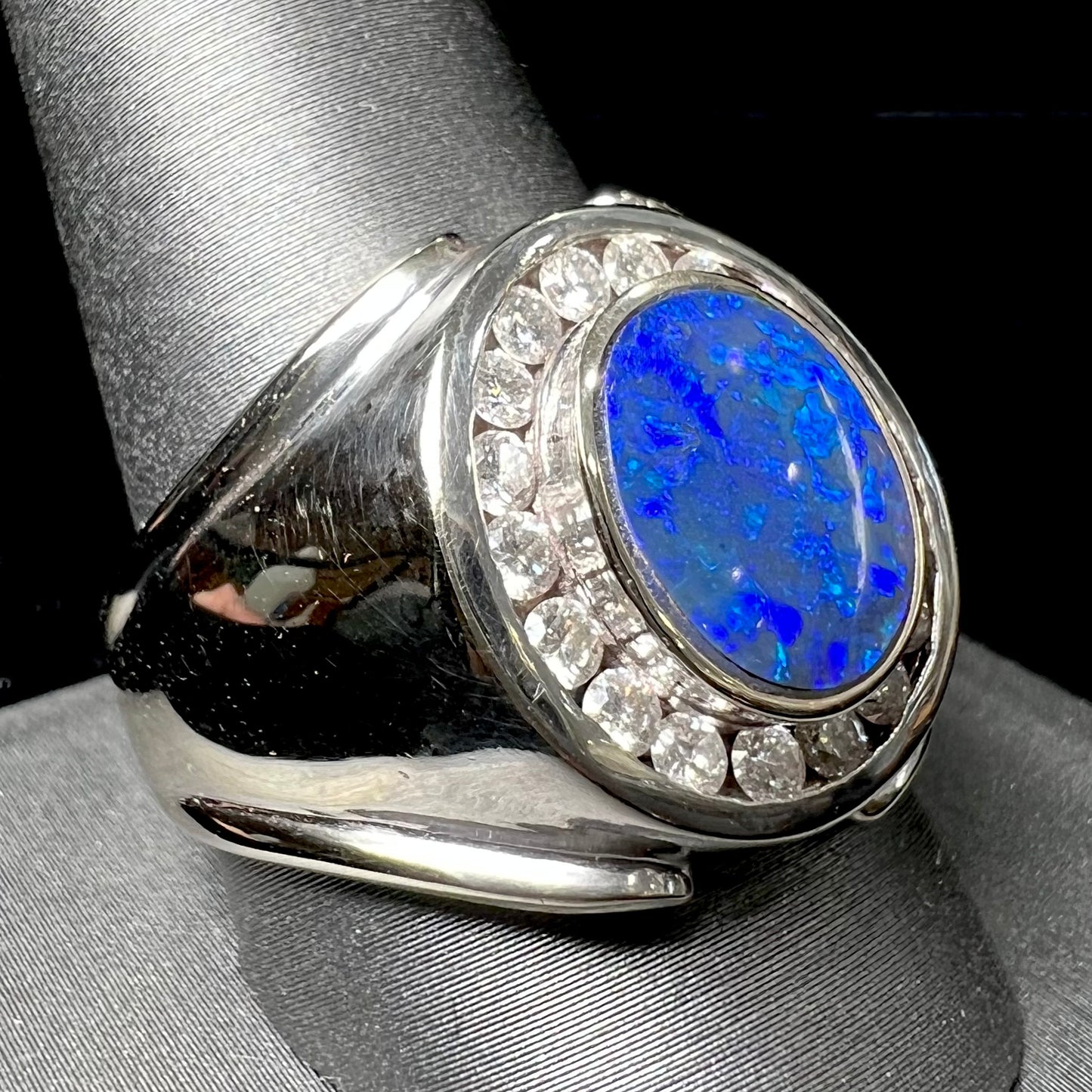 A men's black crystal opal and diamond halo ring in white gold.