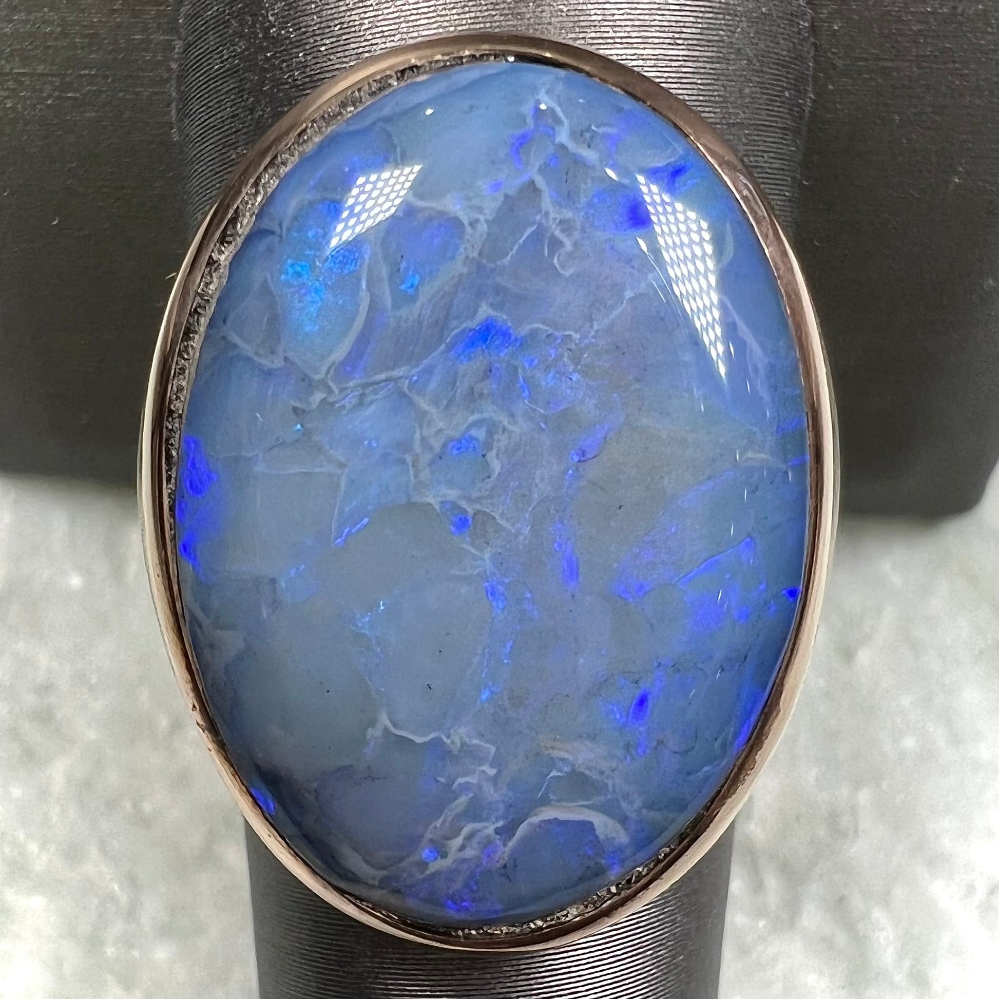 A Lightning Ridge black opal men's ring in solid yellow textured gold.