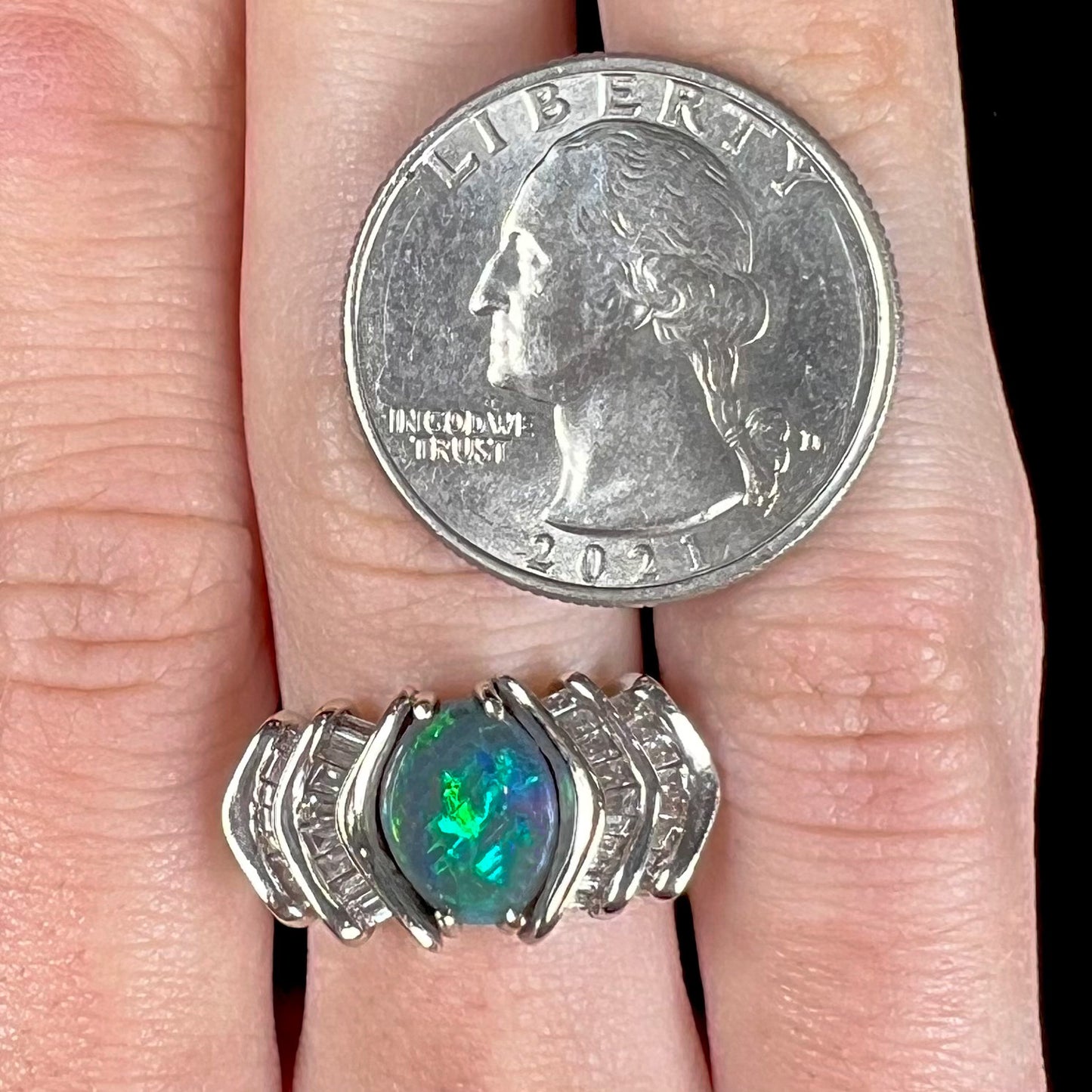 A white gold ring set with a Lightning Ridge natural black opal and baguette cut diamonds.