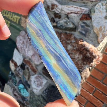 A large, loose, polished Quilpie boulder opal stone from Queensland, Australia.  The stone is blue.