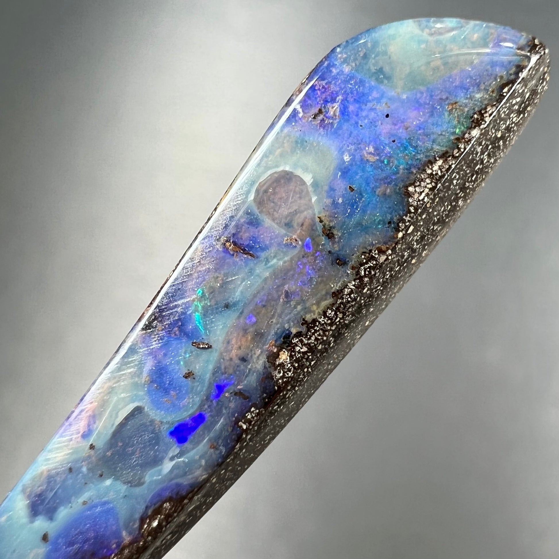 A loose, polished Quilpie boulder opal stone from Australia.  The stone is predominantly blue.