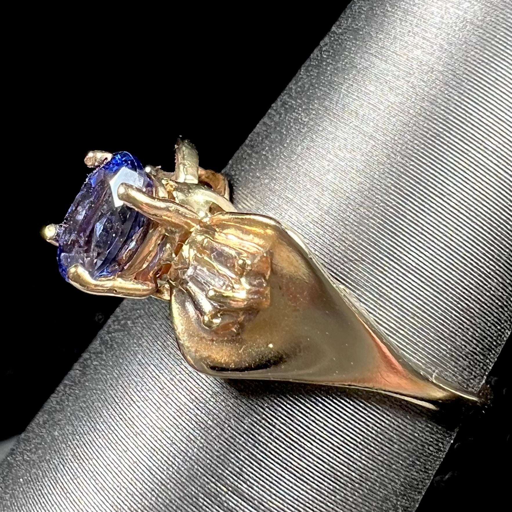 A natural blue sapphire and diamond baguette ring cast in yellow gold.