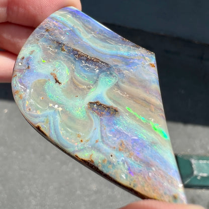 A polished boulder opal stone from Queensland, Australia.