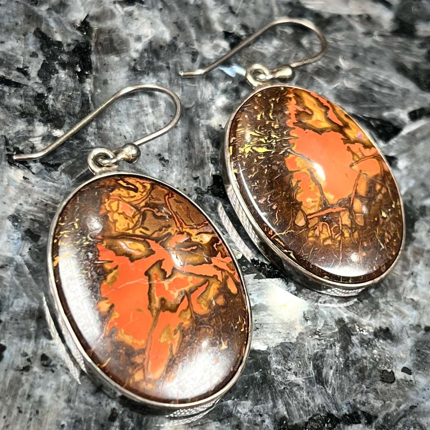 A pair of bezel set, French wire boulder opal dangle earrings in sterling silver.