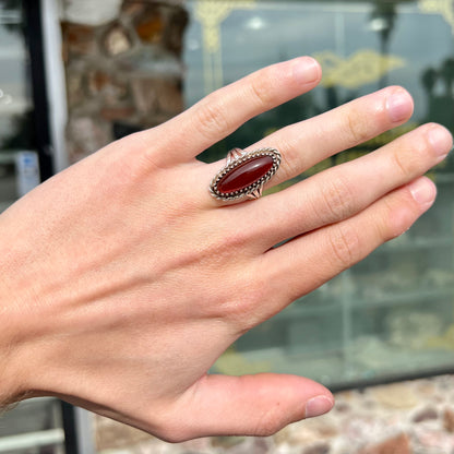 A split shank silver ring set with a brown sard stone in a rope bezel with small prongs.