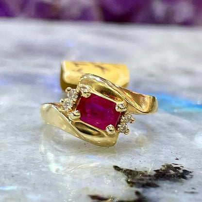 Emerald cut Burma ruby and diamond ring set in 14 karat yellow gold.