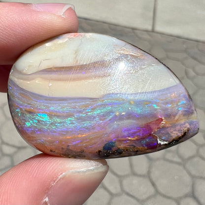 A loose, drop shaped Australian boulder opal from Quilpie Mining District.