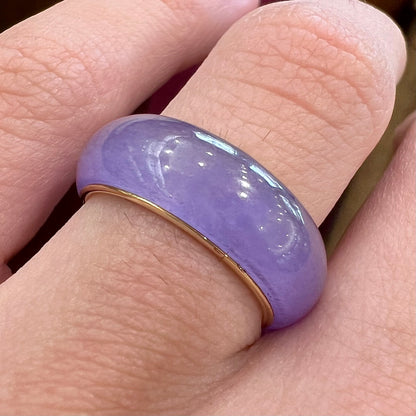 A stone ring carved from purple jadeite jade and mounted on a gold band.