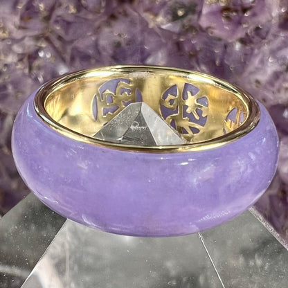 A stone ring carved from purple jadeite jade and mounted on a gold band.