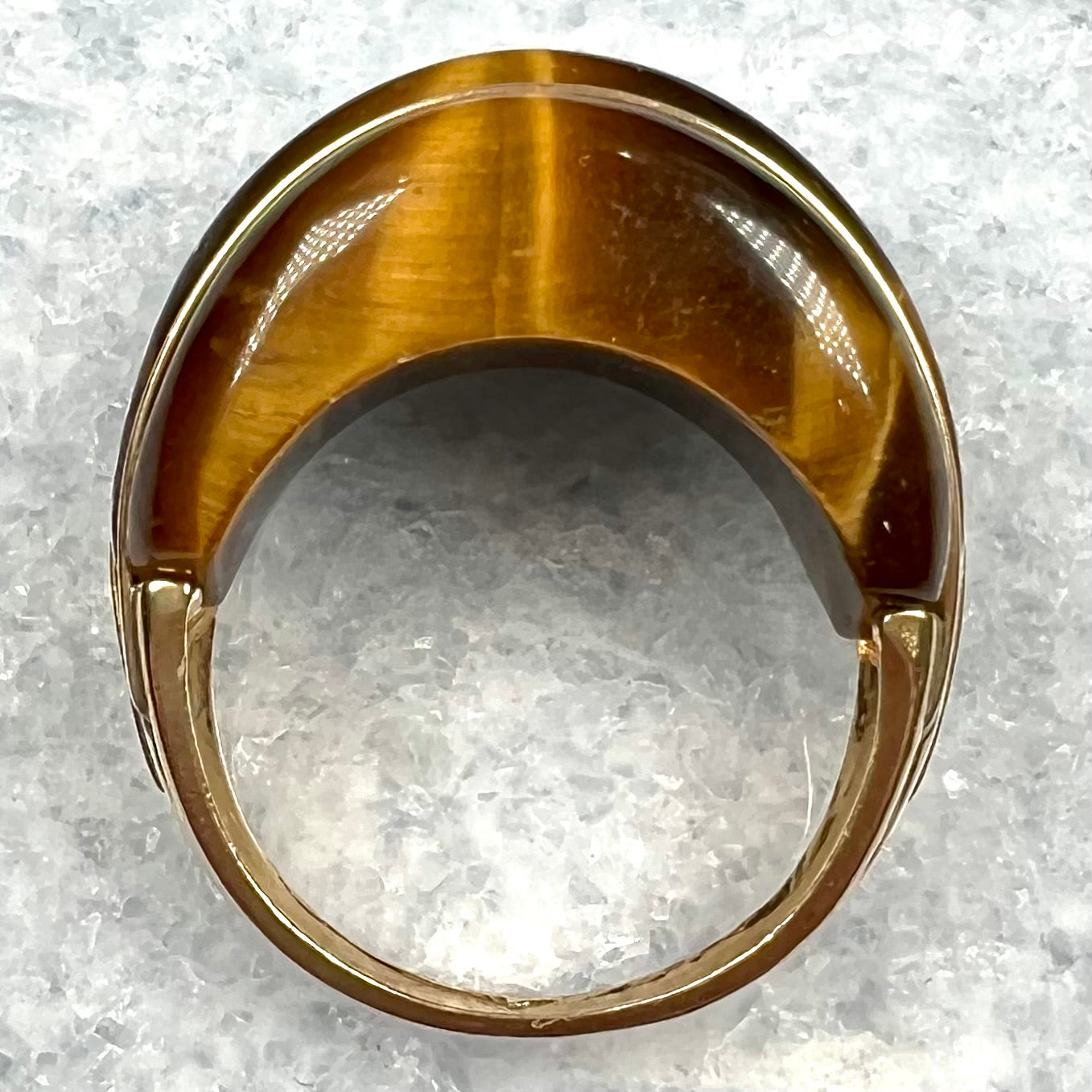 A ladies' high dome carved tiger's eye ring cast in yellow gold.