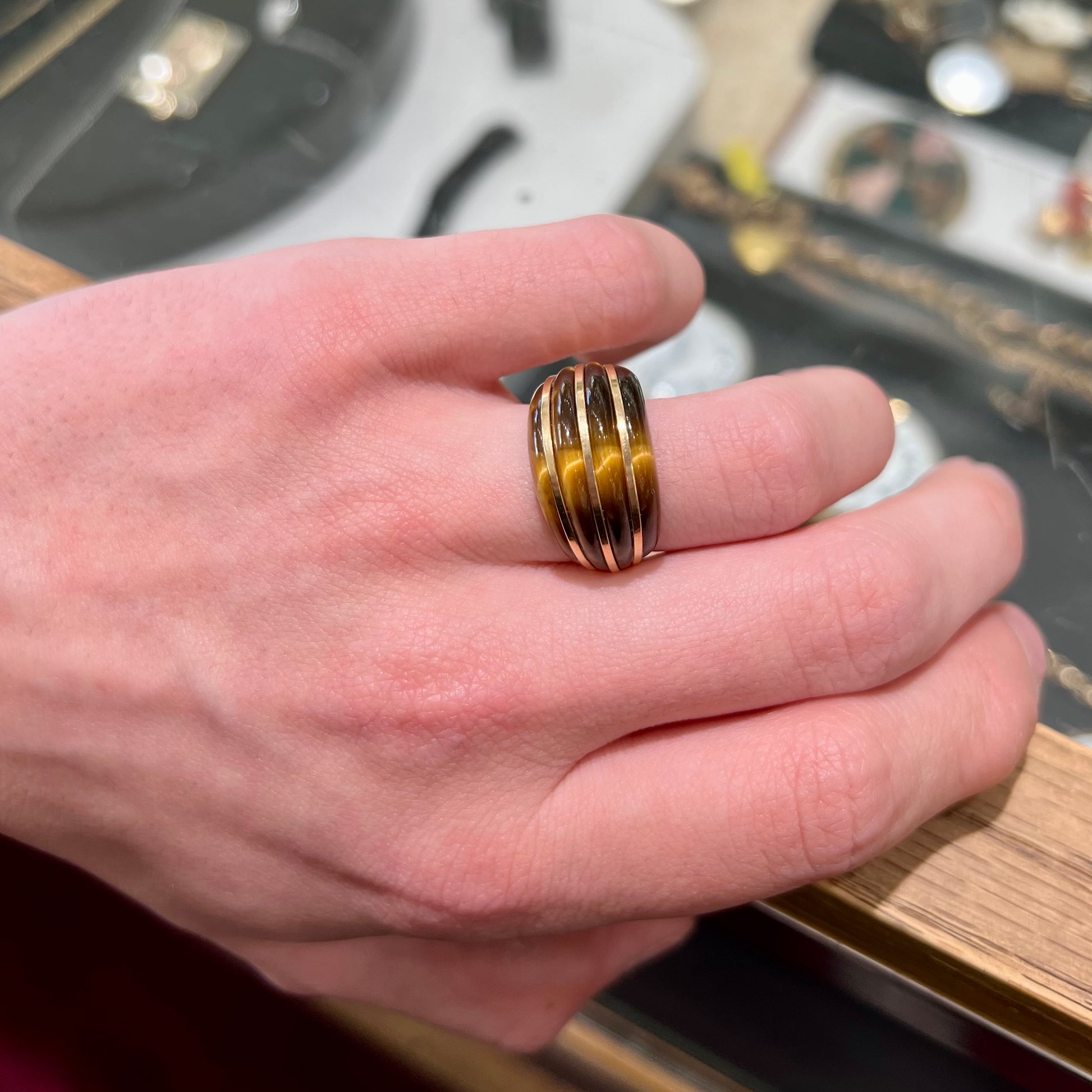 A ladies' high dome carved tiger's eye ring cast in yellow gold.