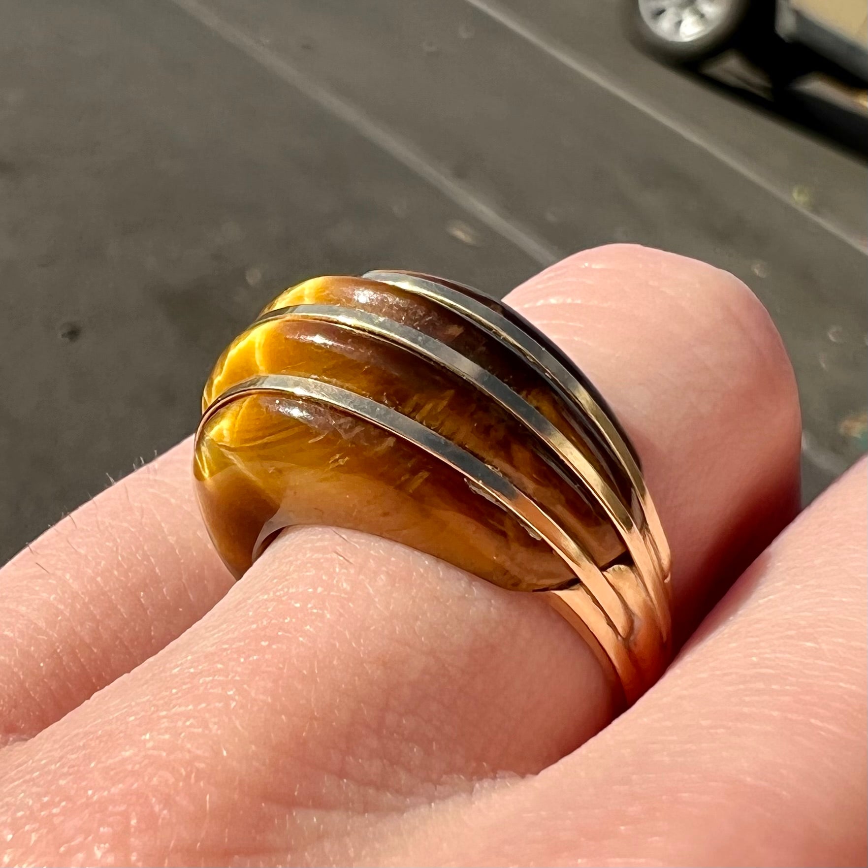 A ladies' high dome carved tiger's eye ring cast in yellow gold.