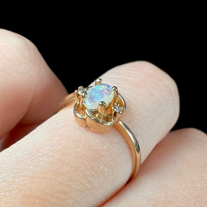 A dainty ladies' yellow gold opal and diamond accent ring.