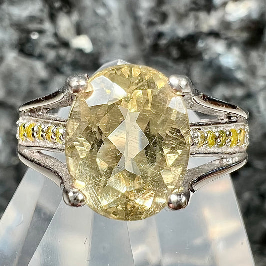 A sterling silver oval cut citrine ring set with canary yellow diamond accents.