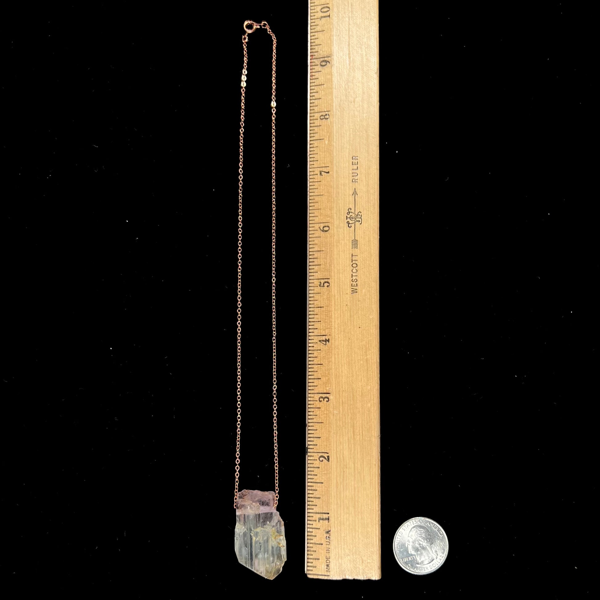 A drilled bicolor spodumene crystal hanging on a copper cable chain.  The crystal is pink and yellow, or kunzite and triphane respectively.