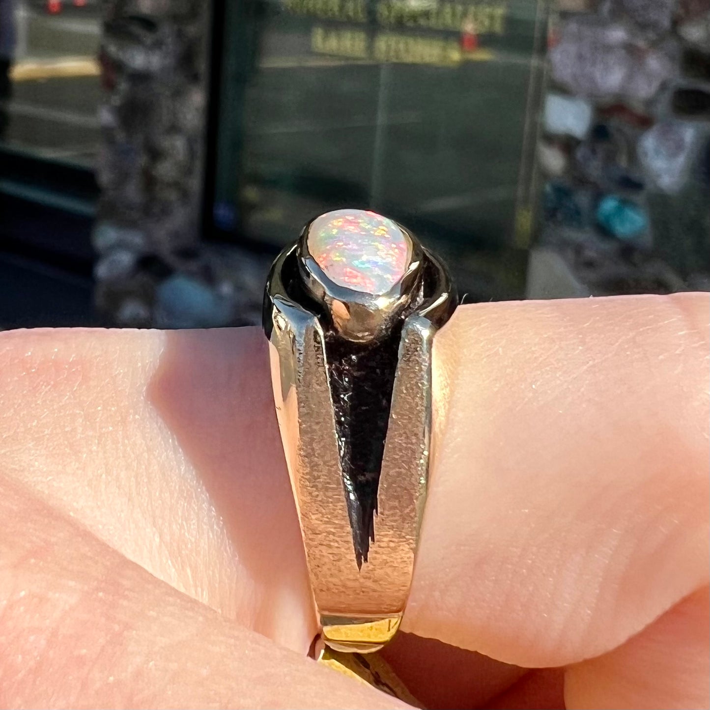 An Australian white crystal opal men's ring in solid yellow gold.  The recesses of the ring have been blackened.