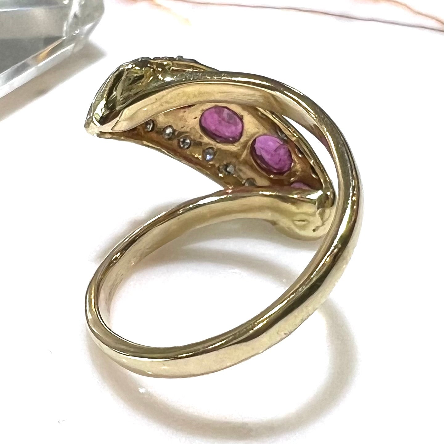 A custom freeform design yellow gold twisted shank ring set with five oval cut rubies and small round diamonds.