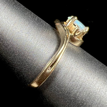 A dainty ladies' yellow gold opal and diamond accent ring.